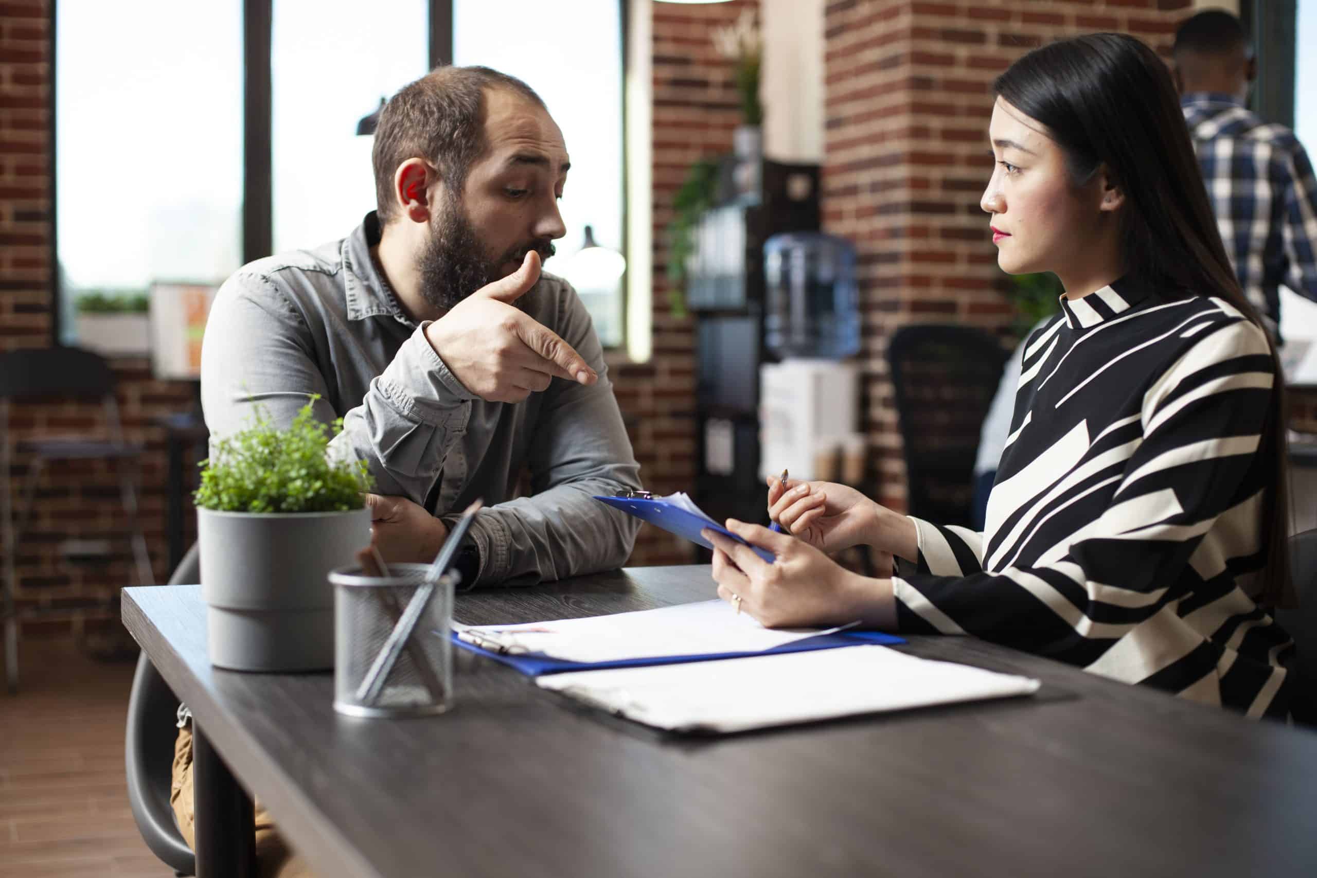 Business meeting between an insurance broker and client in Bonnyville office.