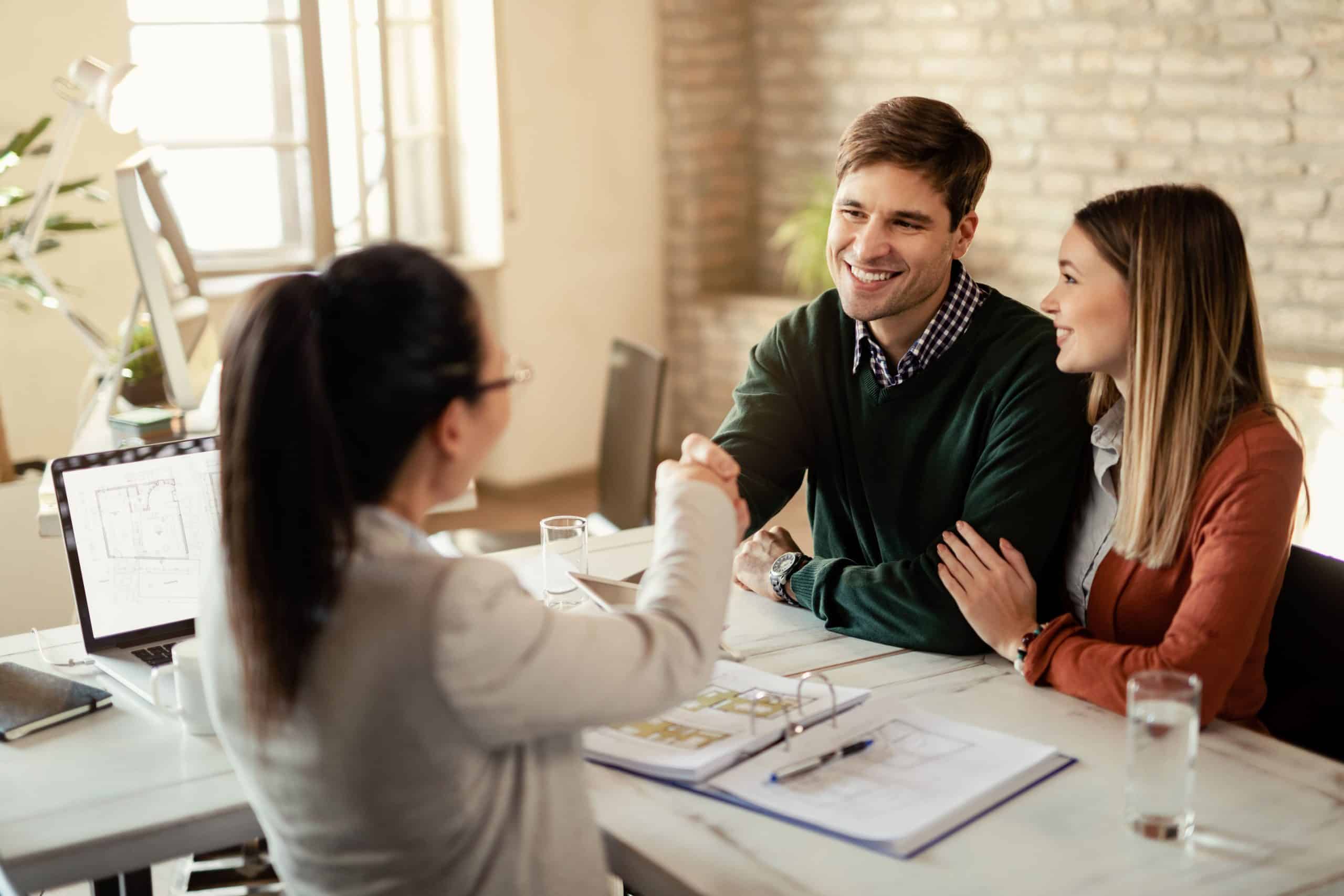 Insurance broker discussing policies with clients in an office setting.