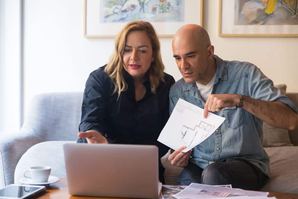 Couple reviewing insurance documents on a laptop at home.